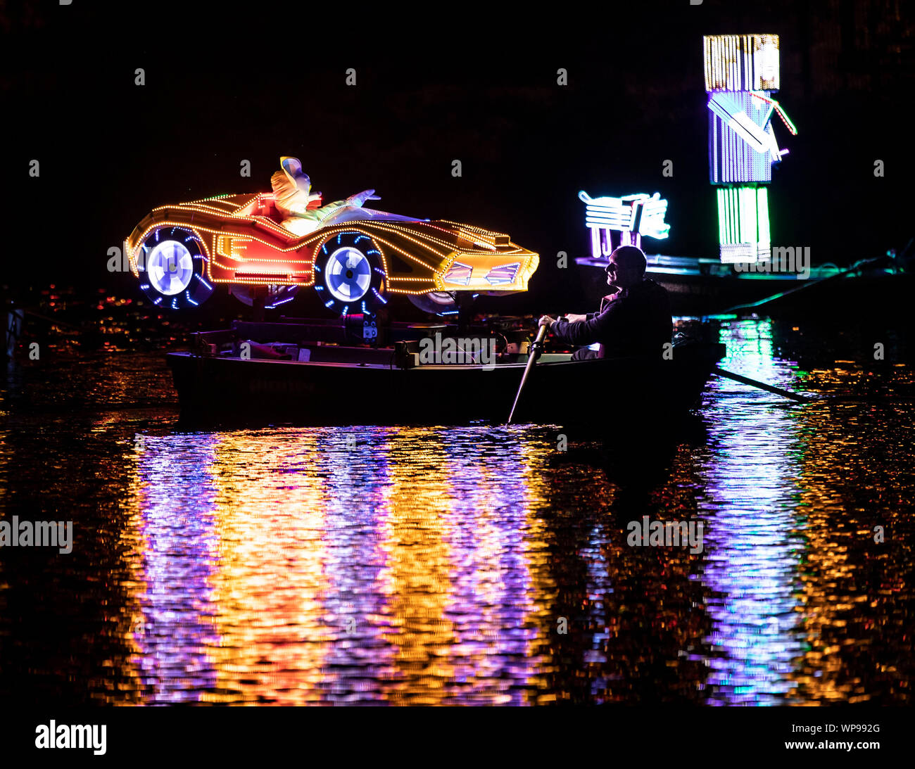 Eine Flotte von hell beleuchteten Booten gerudert sind den Fluss Derwent während der Matlock Bath Illuminationen, in der Peak District, die illuminationen wurden zum ersten Mal Queen Victoria Diamond Jubiläumsfeierlichkeiten im Jahre 1897 zu feiern. Stockfoto