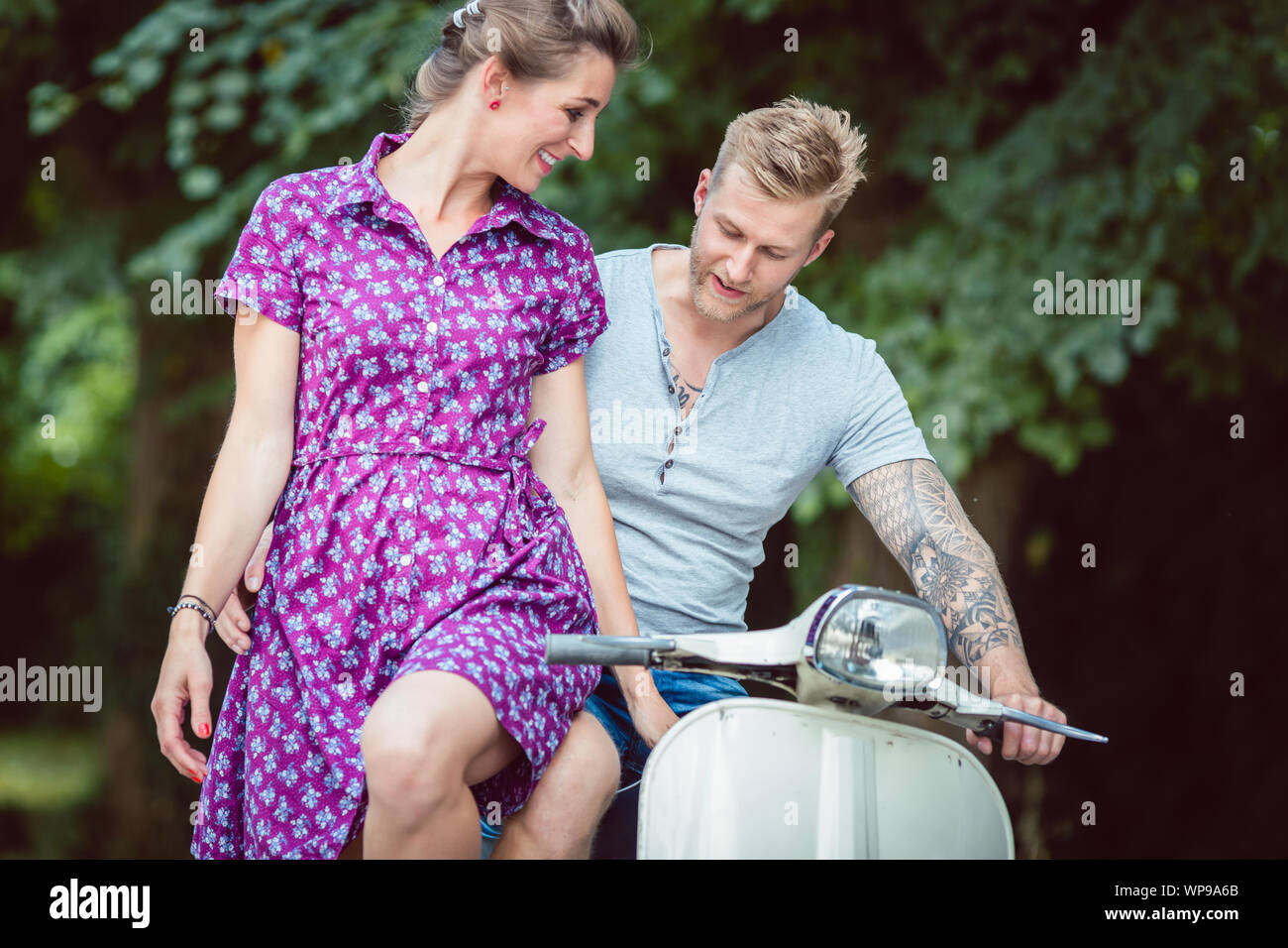 Frau sitzt auf dem Schoß ihres Freundes Stockfoto