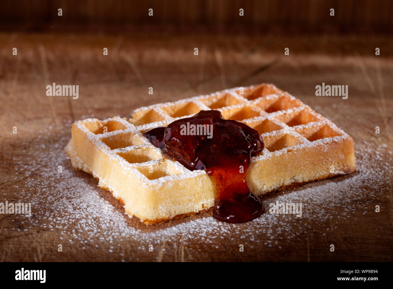 Belgische kuchen Waffel mit Erdbeermarmelade und poder Zucker auf einer hölzernen Hintergrund Stockfoto