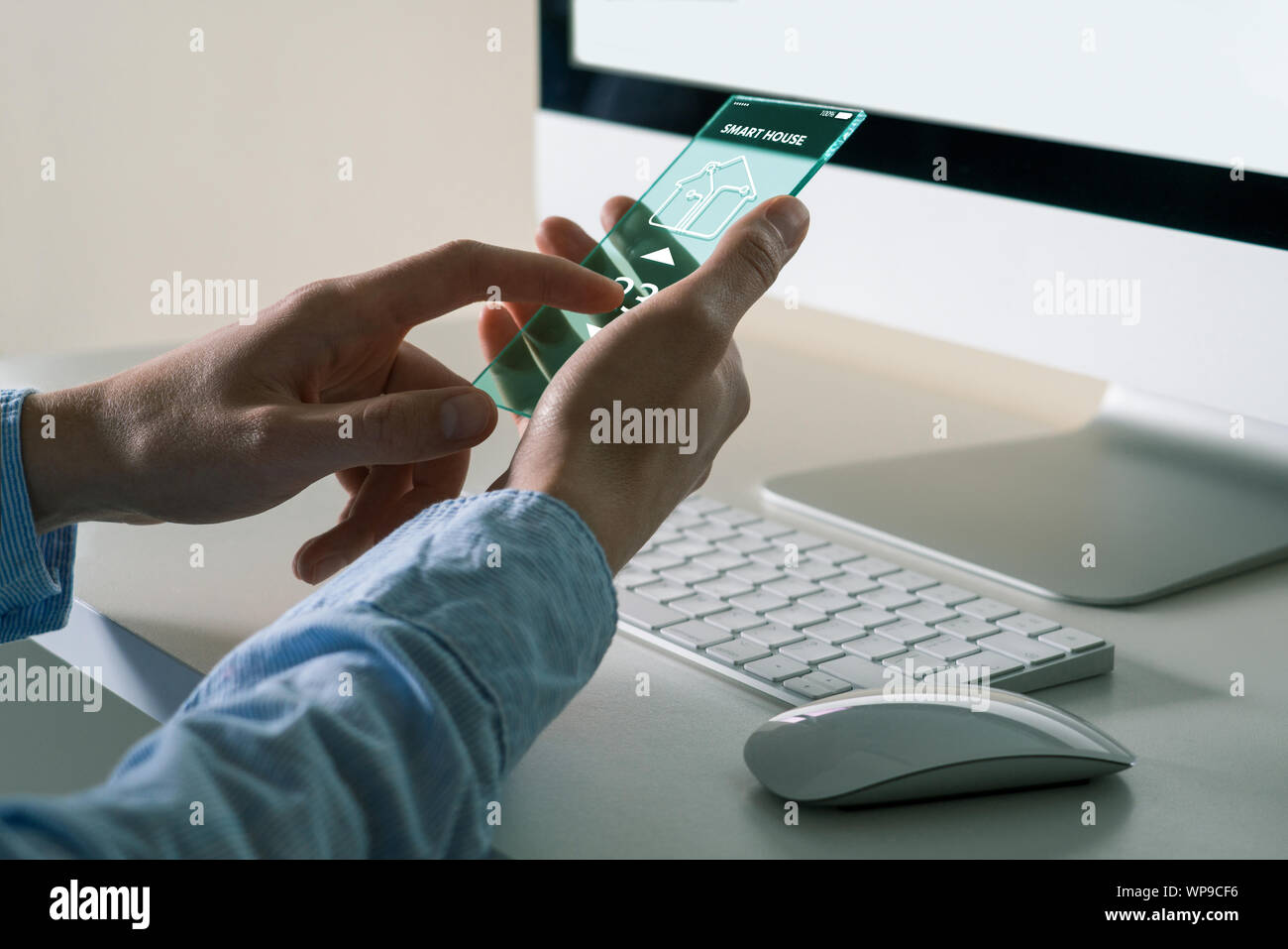 Ein Mann mit einem futuristischen transparente Telefon mit Anwendung für control Smart House. Stockfoto