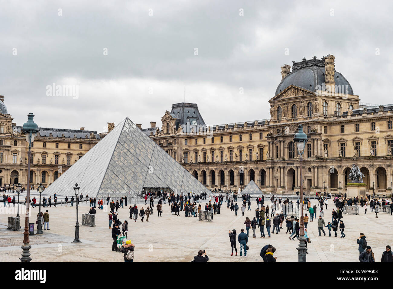 Paris, Frankreich, 28. Januar 2018: Touristen vor dem Eingang des Louvre Museum im Palast Innenhof für regnerische und trübe Tag versammelt. Stockfoto
