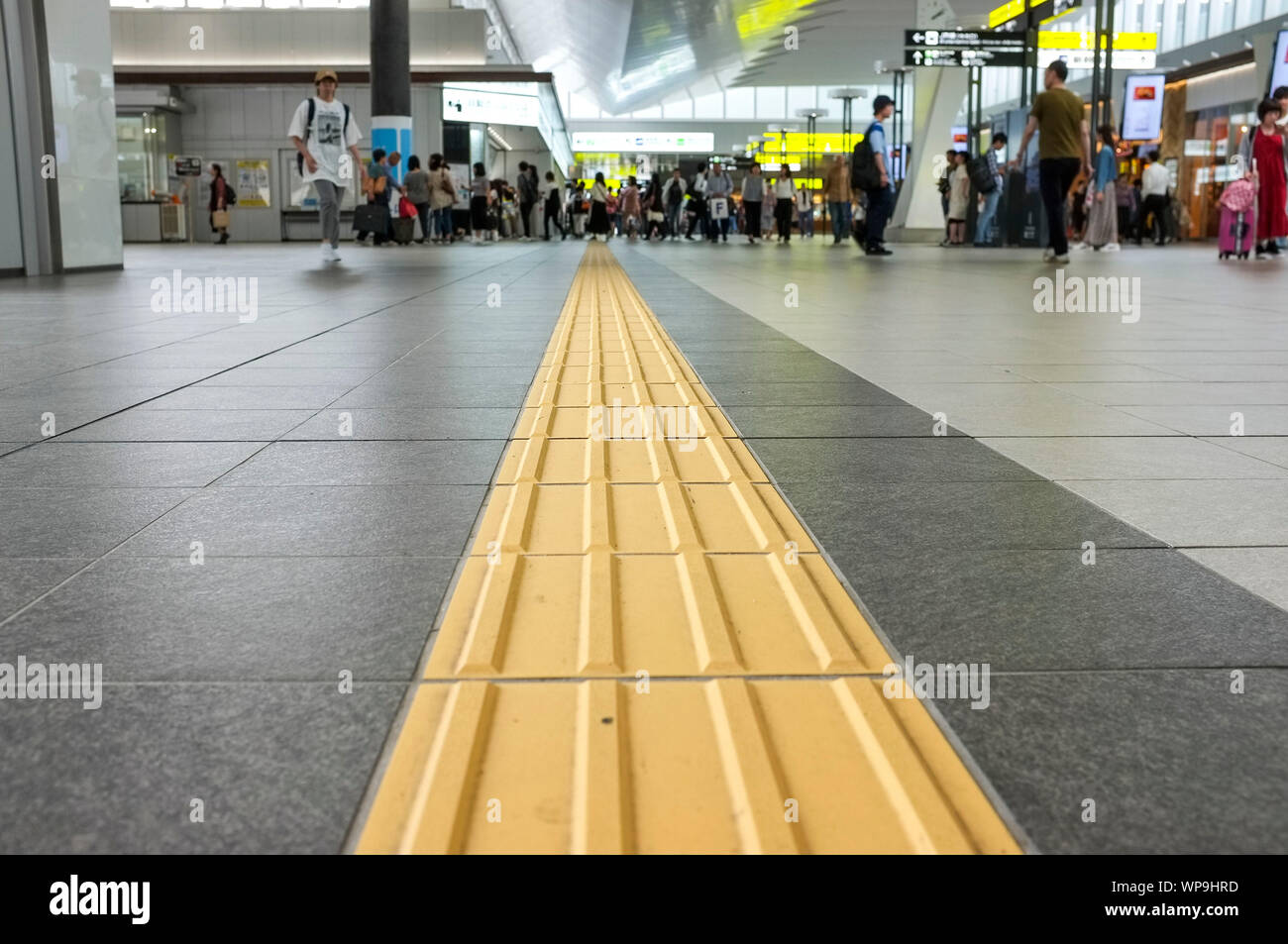 Gelbe Linien "Taktile Boden Indikatoren" (TGSI) oder tenji Bausteine. Im Bahnhof von Osaka in Osaka, Japan. Stockfoto