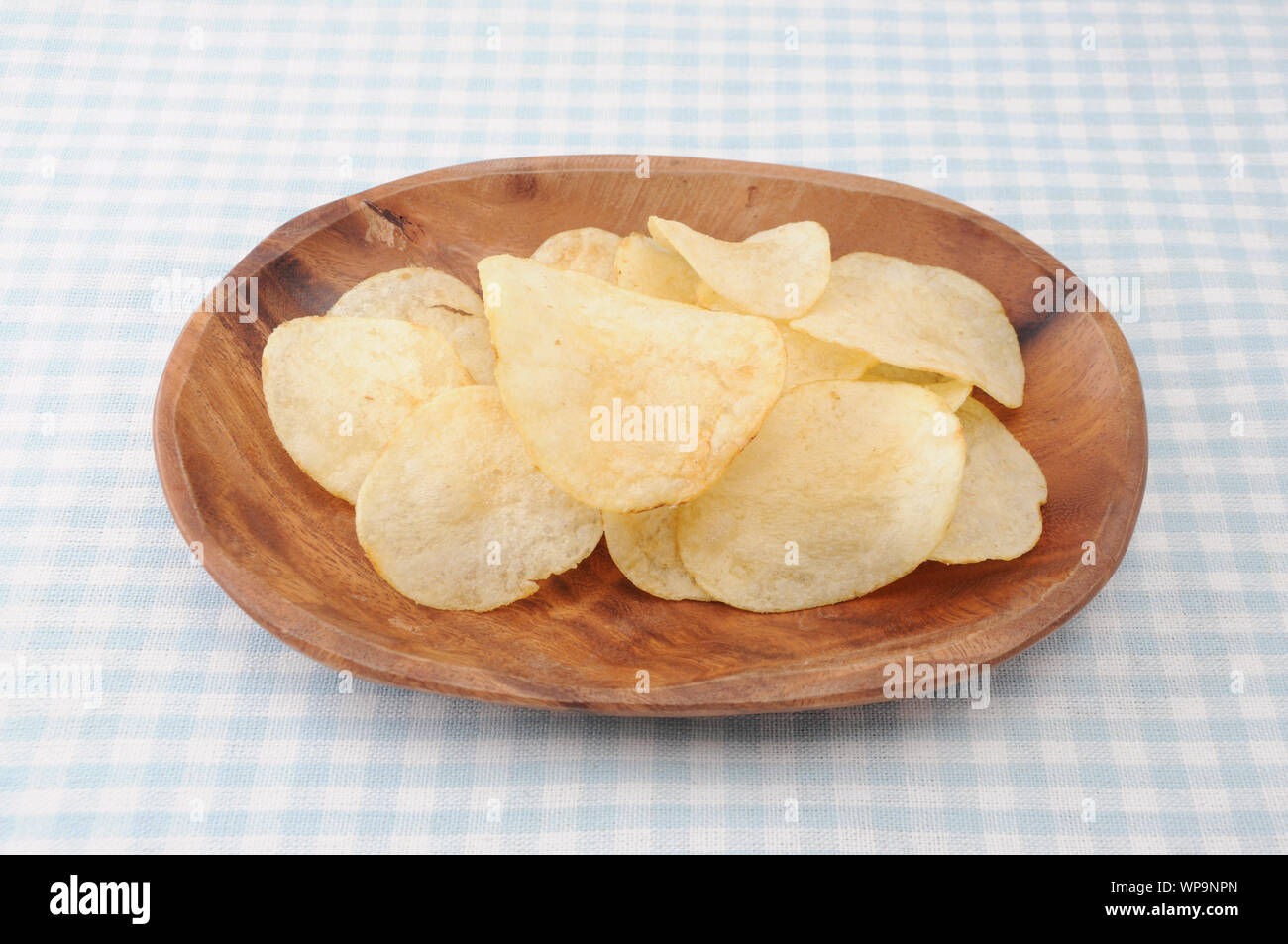 Kartoffelchips auf Holz Platte auf Tischdecke isoliert Stockfoto