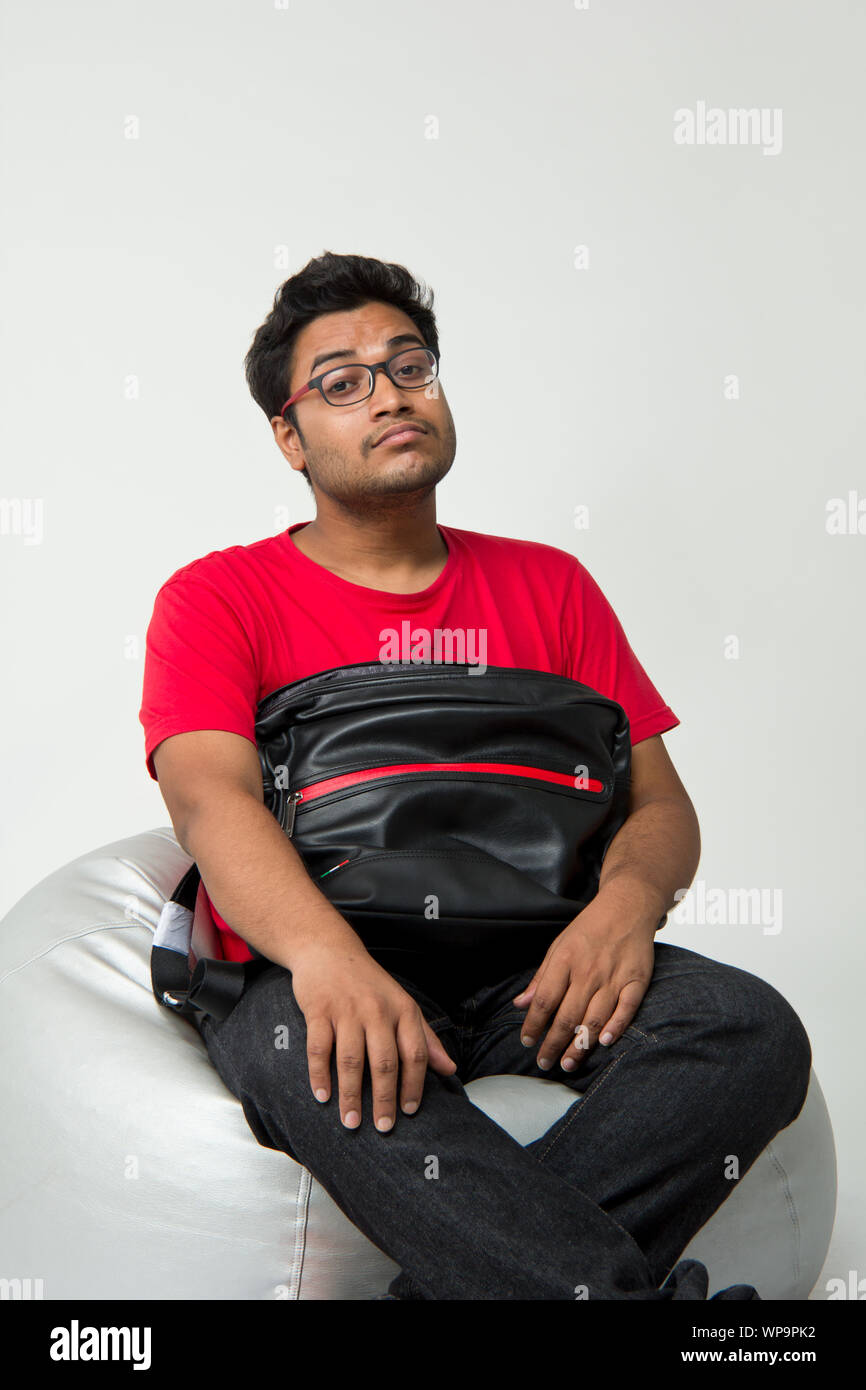 College-Student sitzt auf Sitzsack mit einer Buch-Tasche Stockfoto