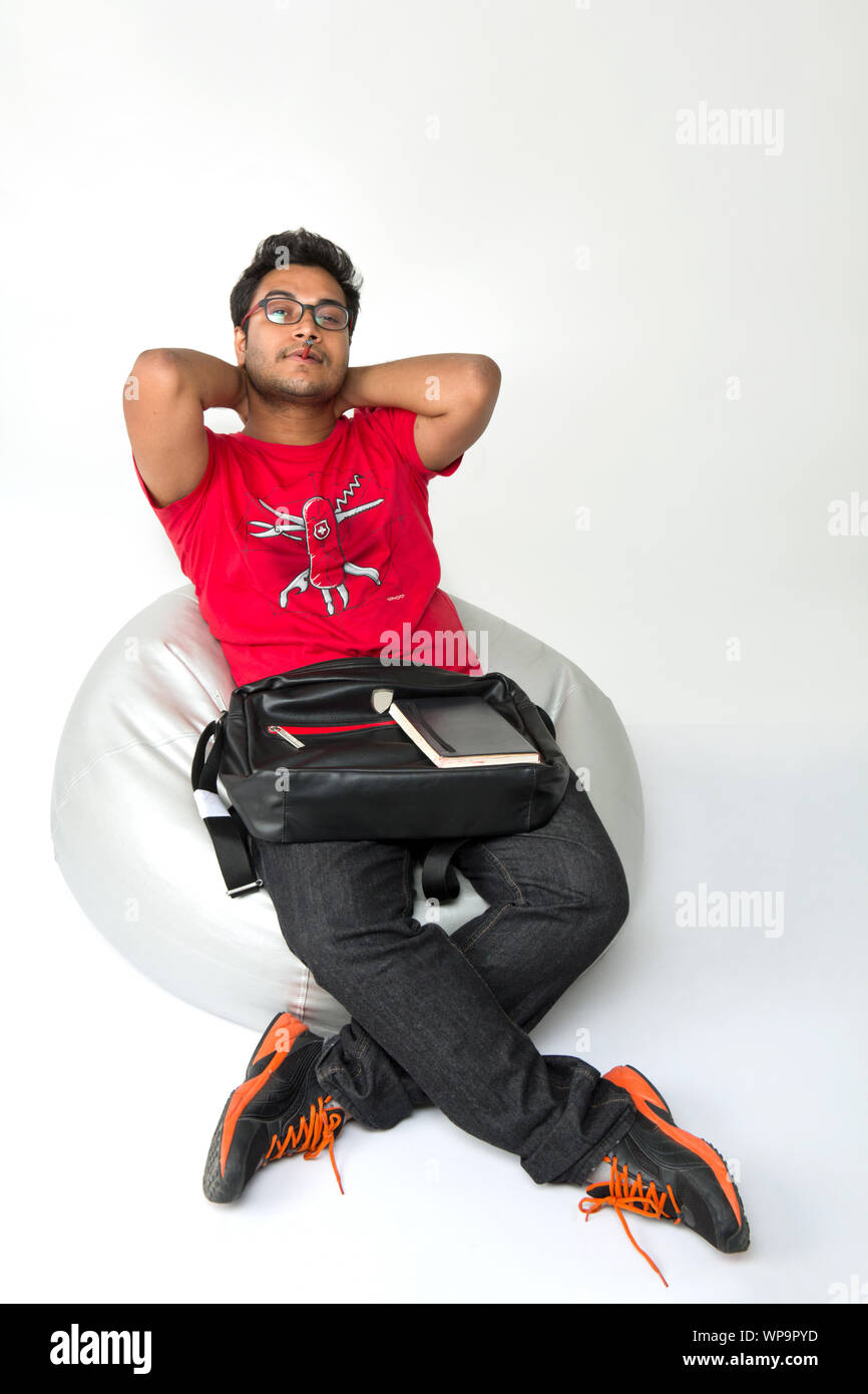 College-Student sitzt auf Sitzsack mit einer Buch-Tasche Stockfoto