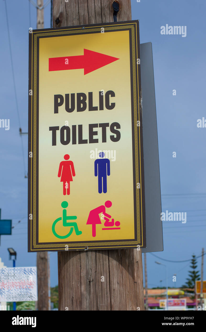 Schild mit weit bekannte Symbole und die Inschrift "öffentliche Toiletten" Nahaufnahme (Griechenland) Stockfoto