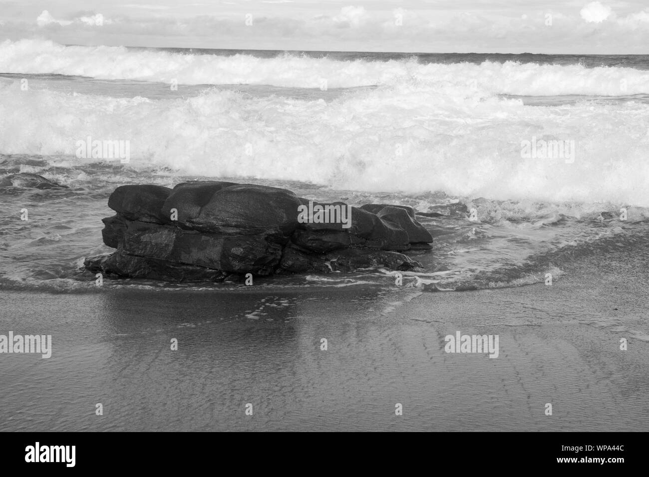 Tide ist in. Teufelskreis Kurven mit der Flut Absturz vor der Küste mit einem sehr starken Rückspülung. Die Brandung ist Schaumig an einem bewölkten Tag. Stockfoto