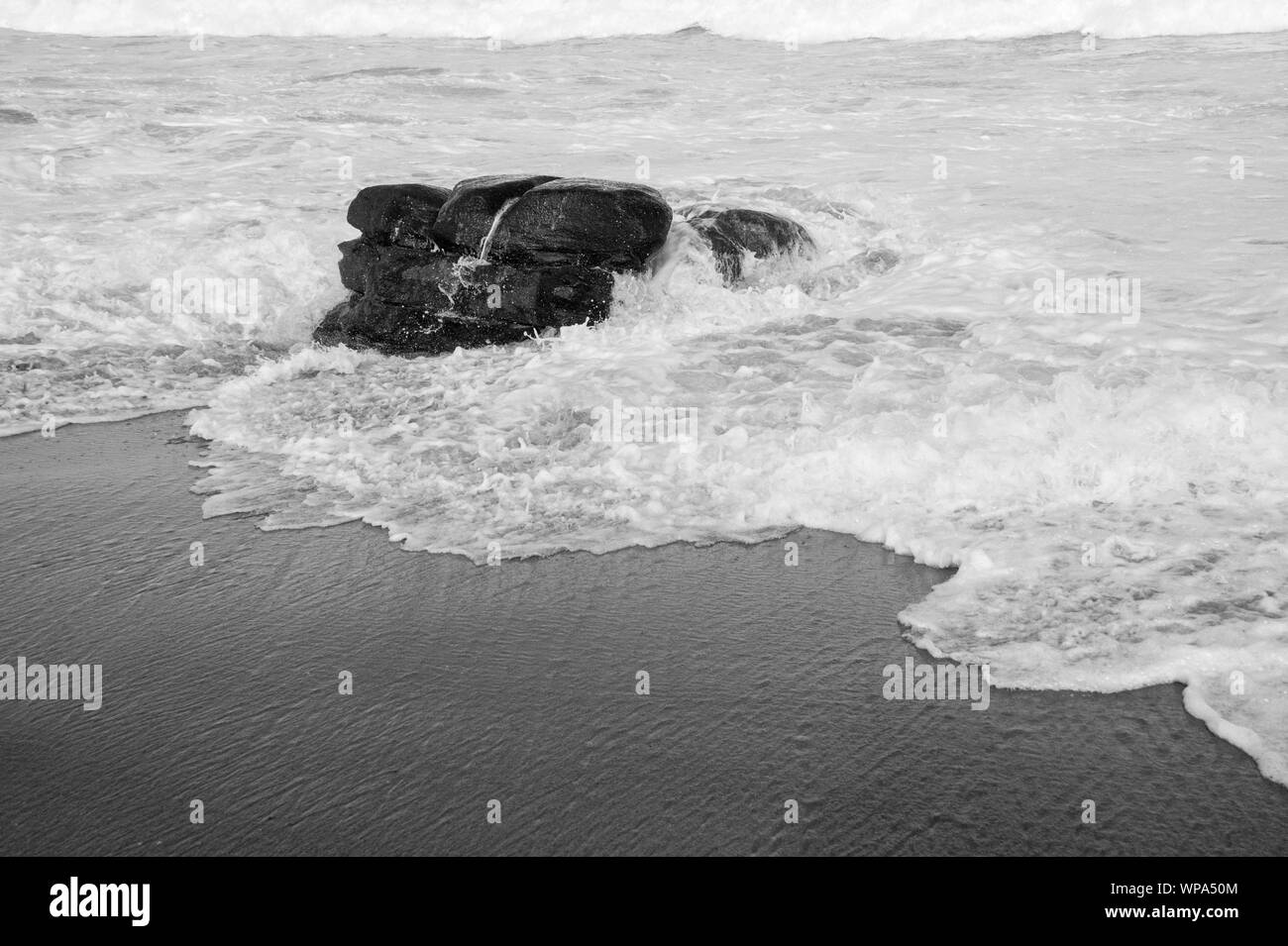 Tide ist in. Teufelskreis Kurven mit der Flut Absturz vor der Küste mit einem sehr starken Rückspülung. Die Brandung ist Schaumig an einem bewölkten Tag. Stockfoto