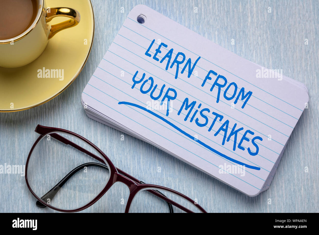 Aus Fehlern lernen - Erinnerung an einen Stapel Karteikarten mit einer Tasse Kaffee, Lernen, Entschlossenheit und Ausdauer Konzept Stockfoto