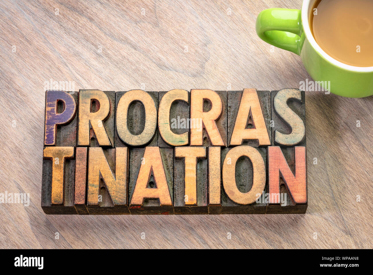 Procrastination word Abstract in Vintage buchdruck Holzart mit einer Tasse Kaffee, Effizienz und Produktivität Konzept Stockfoto