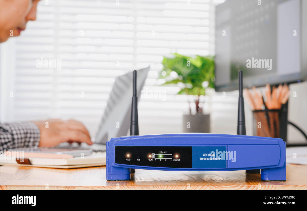 Wireless Router und mit einem Laptop im Büro Mann. Router Wireless Broadband home Laptop Telefon WLAN-Konzept Stockfoto