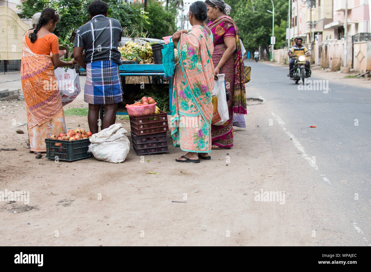 Indische Frauen Gemüse kaufen von einem Straße Verkäufer Warenkorb Stockfoto