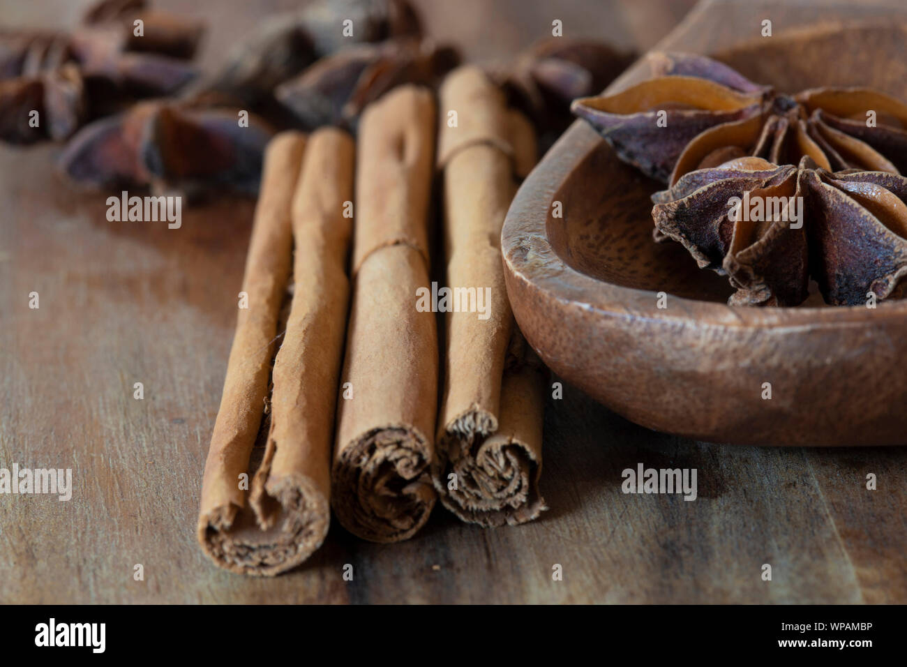 Sternanis in Löffel aus Holz mit Zimt auf Holz Schneidebrett. Aromatische Gewürze Stockfoto