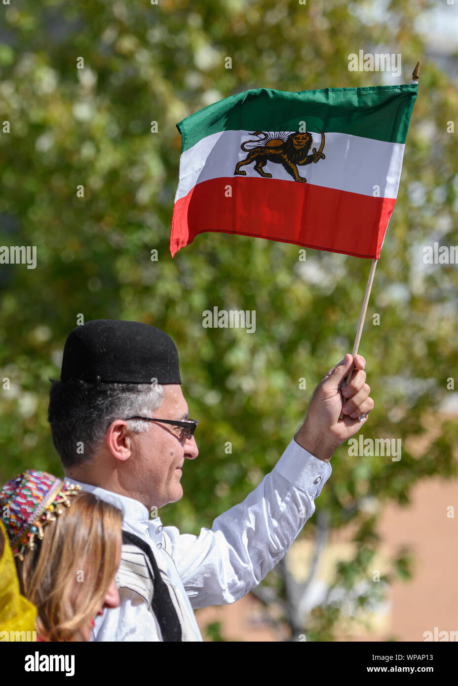 Ein Mann stolz Wellen der iranischen "Löwe und Sonne' (Shir o Khorshid) Flagge von oben auf einen Schwimmer oben auf der Yonge persischen Parade in seinem ersten Jahr. Stockfoto Ein Mann stolz Wellen der iranischen "Löwe und Sonne' (Shir o Khorshid) Flagge von oben auf einen Schwimmer oben auf der Yonge persischen Parade in seinem ersten Jahr. Stockfoto