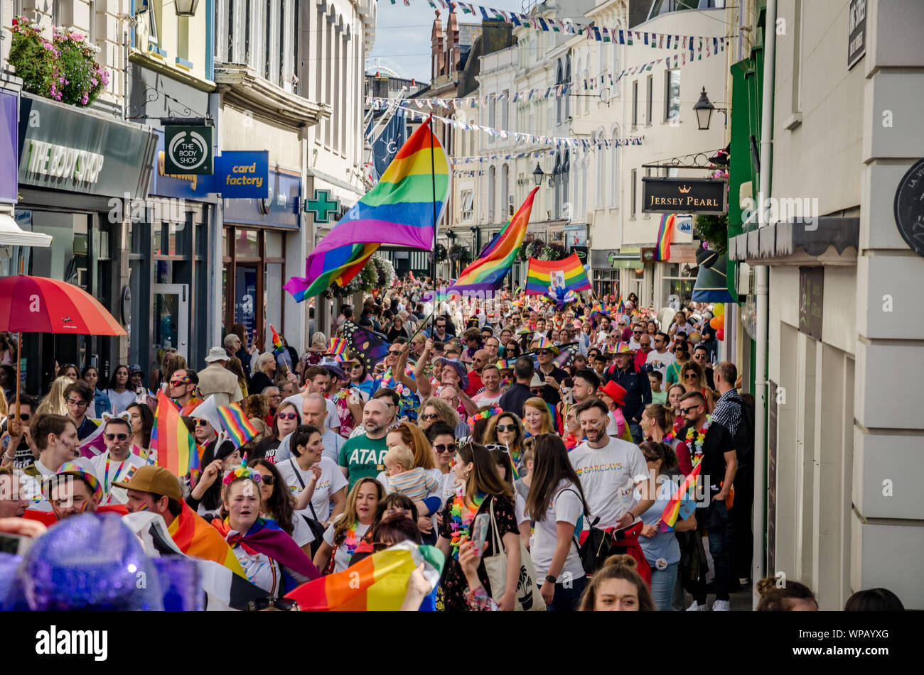 Masse der Leute marschieren mit wehenden Fahnen für Channel Islands Stolz in Jersey 2019 Stockfoto