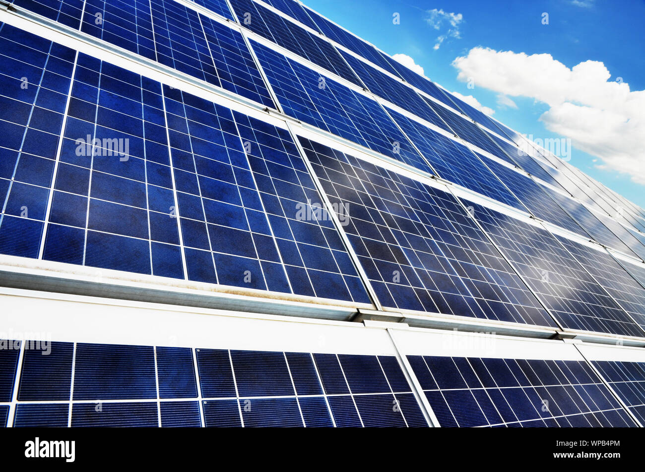 Solarpanels auf dem Dach von Gebäude in der Sonne unter blauem Himmel Stockfoto