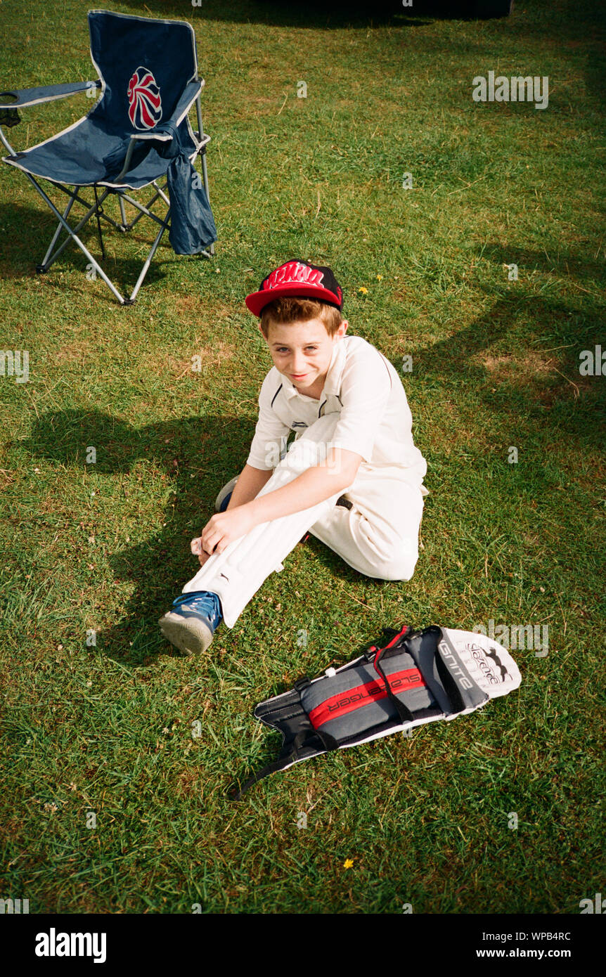 10 Jahre alter Junge wartet ein Cricket-spiel bei Oakley Cricket Club, Hampshire, England, Vereinigtes Königreich zu spielen. Stockfoto