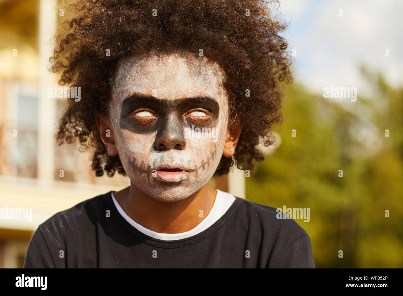 Kopf und Schultern Porträt des Afrikaners - kaufen Sie tragen gruselige Skelett Kostüm posiert im Freien auf Halloween durch Sonnenlicht beleuchtet, kopieren Raum Stockfoto
