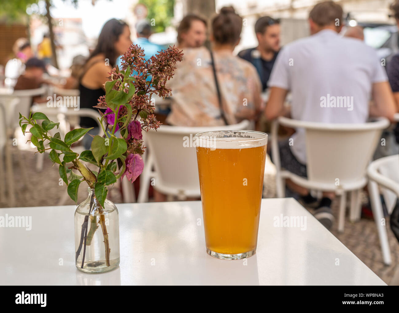 Pint cool IPA am weißen Tisch mit Blumen in Lissabon Bar oder Cafe Stockfoto