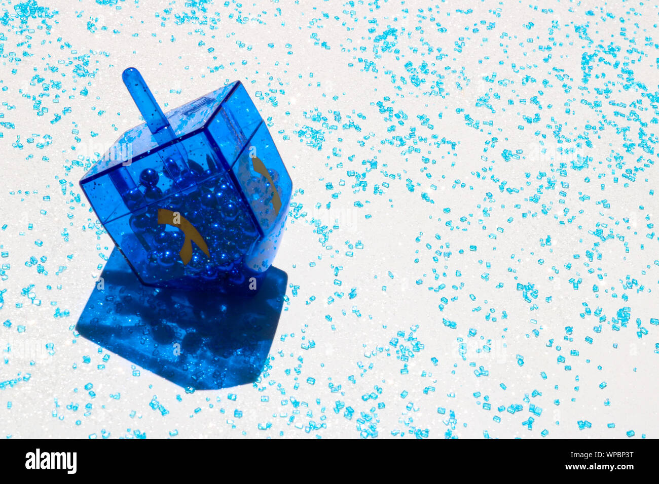 Blau dreidel gegen einen weißen und blauen Glitzer Hintergrund mit Kopie Raum Stockfoto