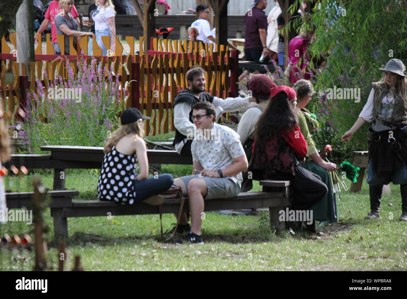 Ein romantisches Paar miteinander reden, während an einem Tisch sitzen im Bristol Renaissance Faire, Feire, Feyre, faire und Fayre, Mittelaltermarkt, mercats Medievals. Stockfoto
