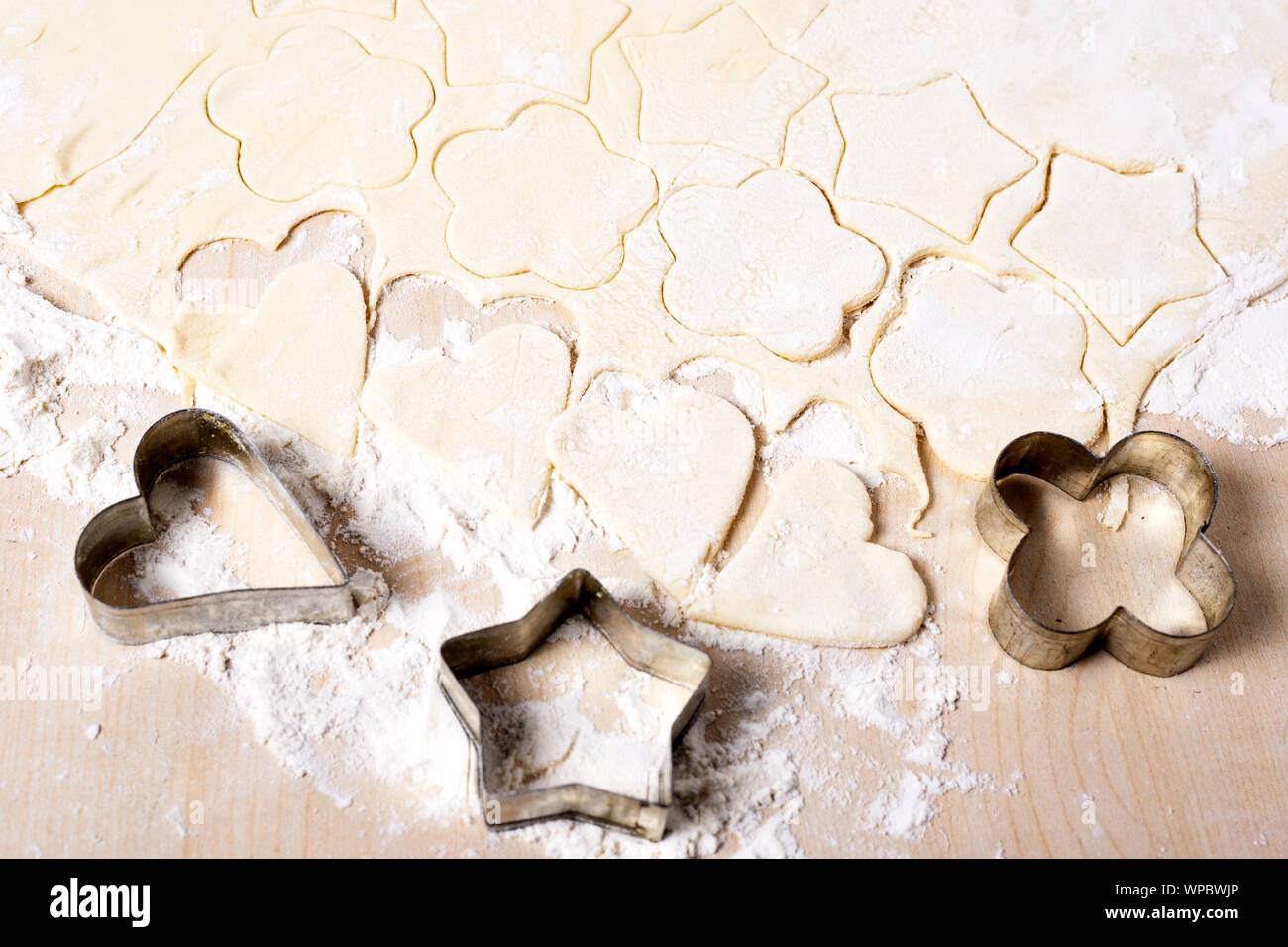 Cooking Cookies in der Form eines Herzens, Stern und Blume auf einem weißen Tisch Stockfoto