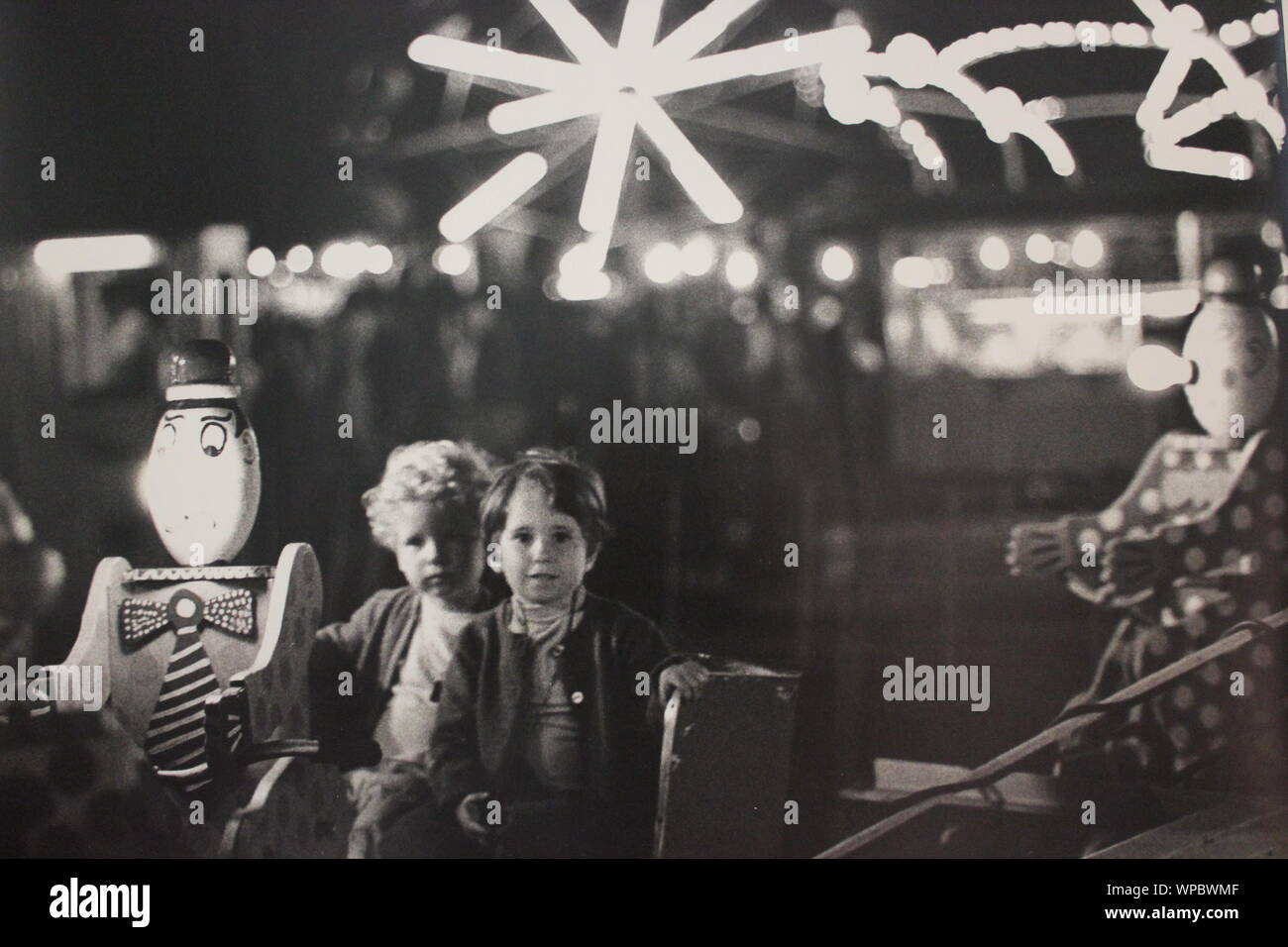 Feine schwarze und weiße Kunst Fotografie von den 1970er Jahren von einem jungen Spaß beim um einen Vergnügungspark laufen und schauen in die Kamera. Stockfoto