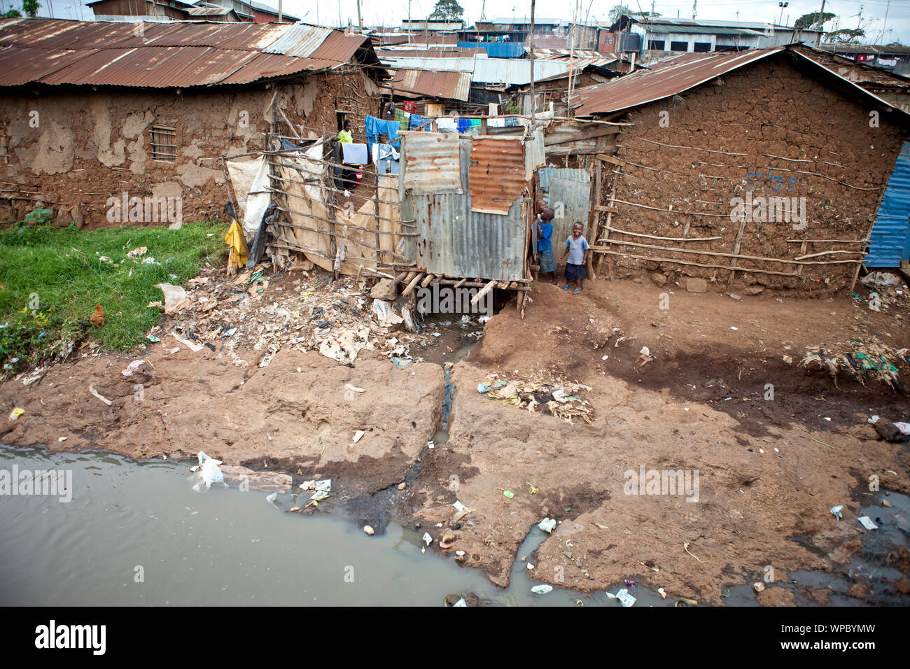 In KIBERA, KENIA - Dezember 6, 2010: Nicht identifizierte Kinder spielen in der Nähe von schmutziges Wasser in Kibera, dem größten städtischen Slum in Afrika. Stockfoto
