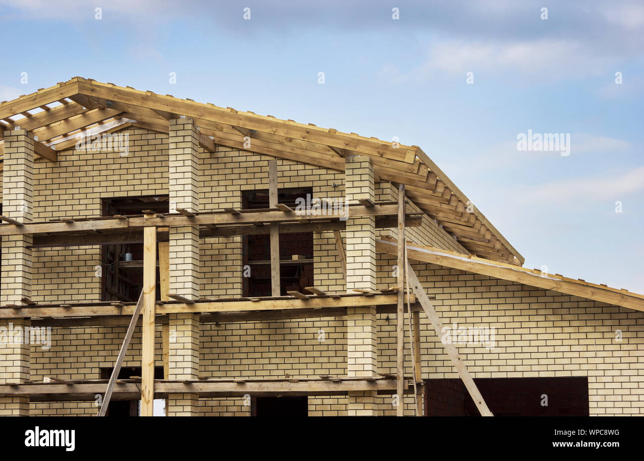 Fragment von Haus aus Backstein mit einem Dach aus Holz im Bau Stockfoto