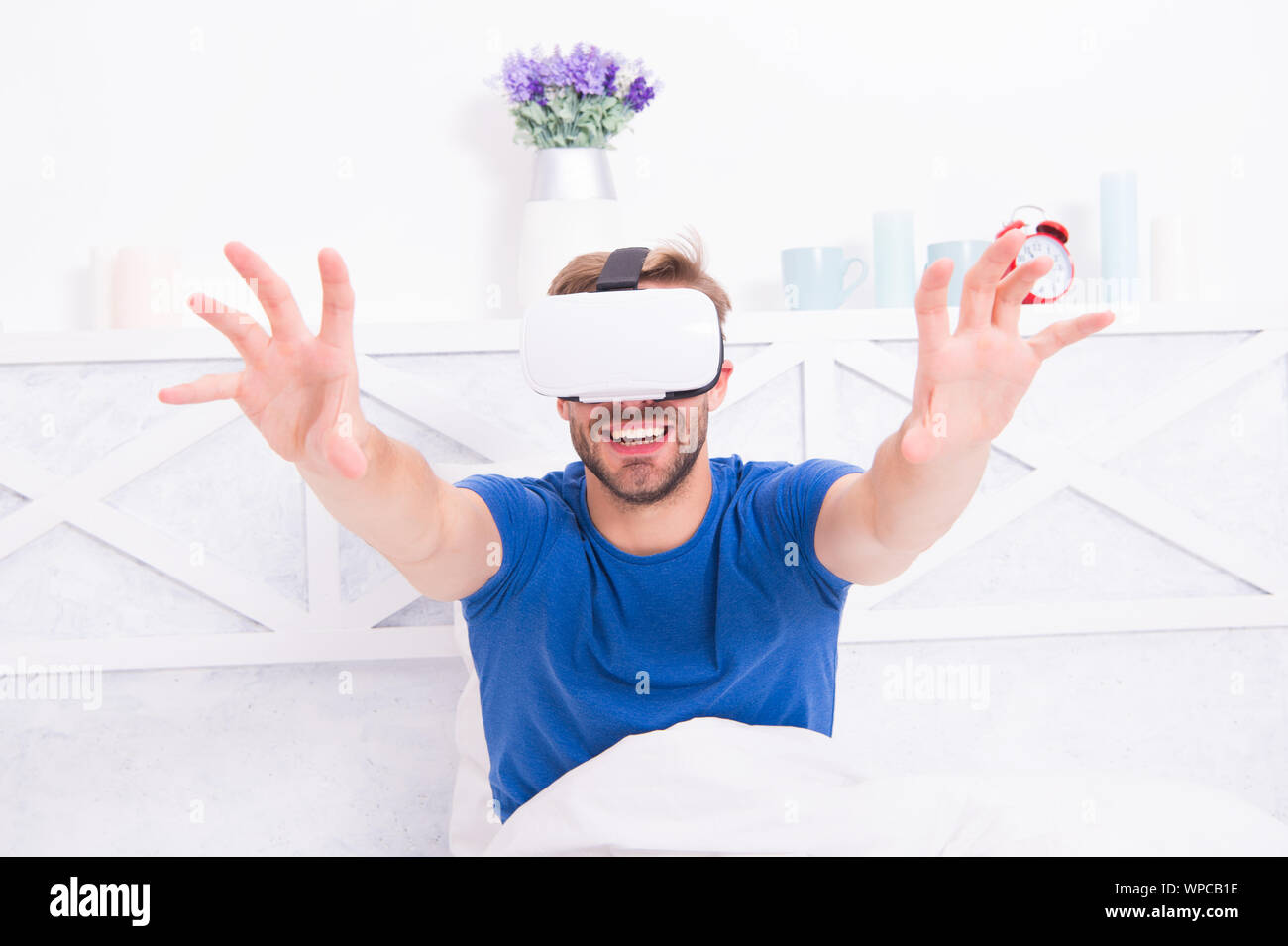 Edv-technisch eine simulierte Umgebung zu erstellen. Happy Guy tragen VR-Headset  für Computerspiele. Schöner Mann spielen virtuelle Computer Spiele im Bett.  Gaming Computer Stockfotografie - Alamy