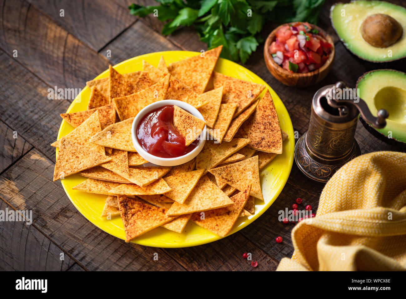 Mexikanische Tortilla Chips Nacho mit Tomatensauce und Salsa auf gelb Platte, Holz- Hintergrund. Tex Mex Essen Stockfoto