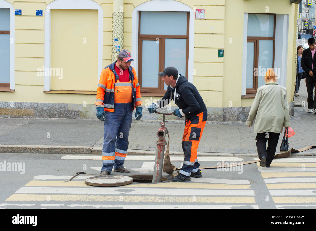 Sankt Petersburg, Russland - Juli 08, 2017: Arbeitnehmer in Overalls installieren Sie ein hydrant und ein Schlauch in die Wasserversorgung befestigen Stockfoto