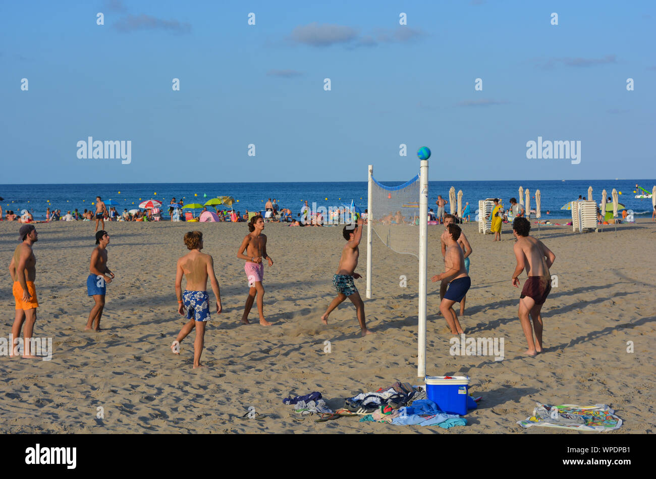 Gruppe junger Männer spielen Beachvolleyball am Strand Arenal in Javea an der Costa Blanca, Spanien. Am späten Nachmittag im Sommer Stockfoto