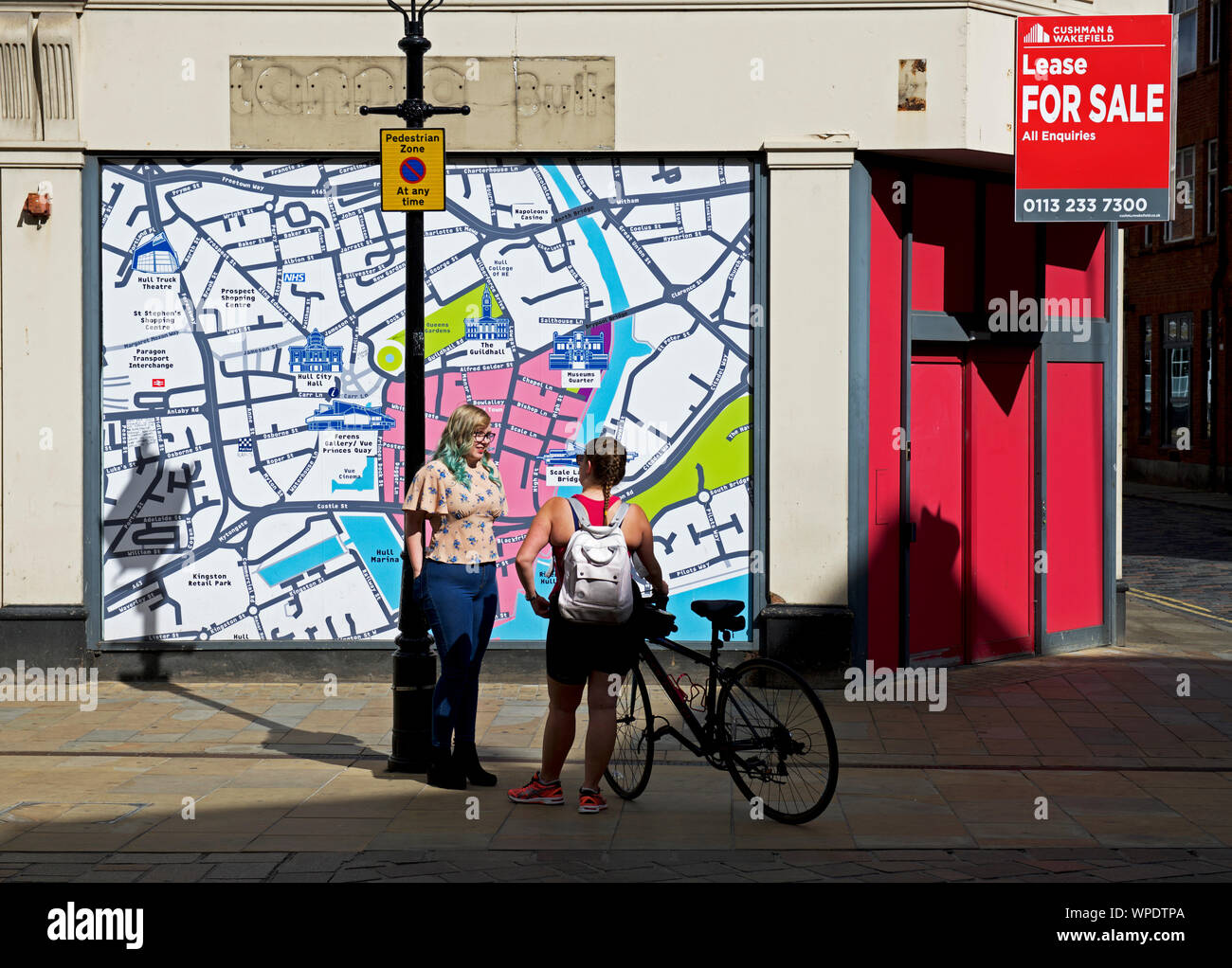 Zwei junge Frauen Chatten in Prospect Street, vor einer Karte der Stadt, Hull, East Yorkshire, England, Großbritannien Stockfoto