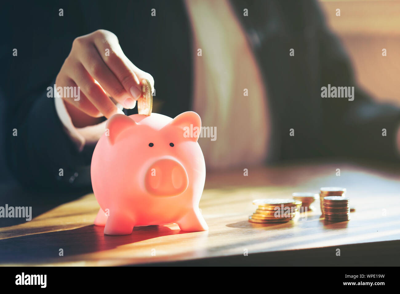 Close up Business weibliche Hand Münze in piggy Bank Stockfoto