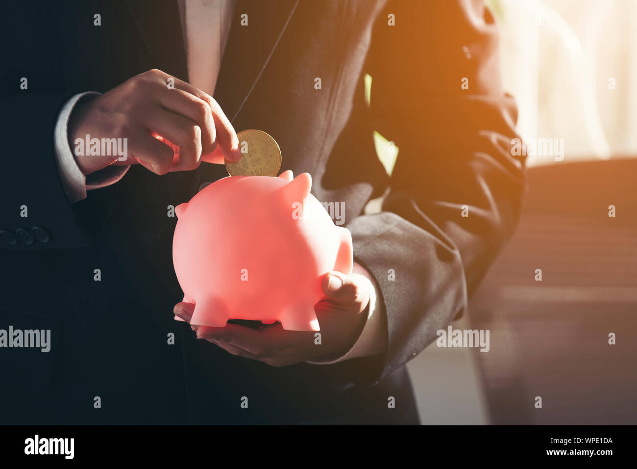 Geschäftsmann Hand Münze in piggy Bank Stockfoto