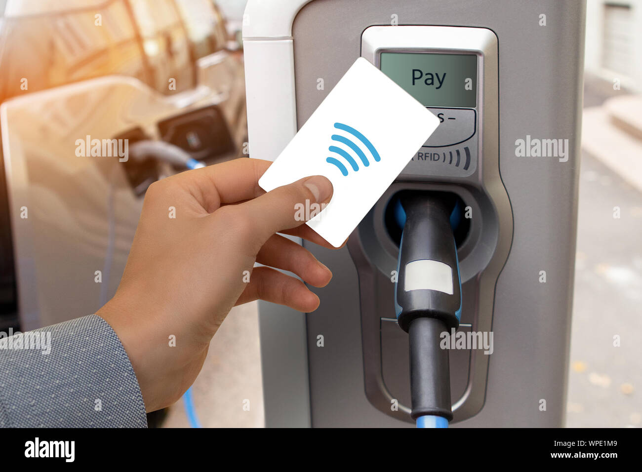 Ein Mann zahlt für das Aufladen eines Elektroautos. Stockfoto