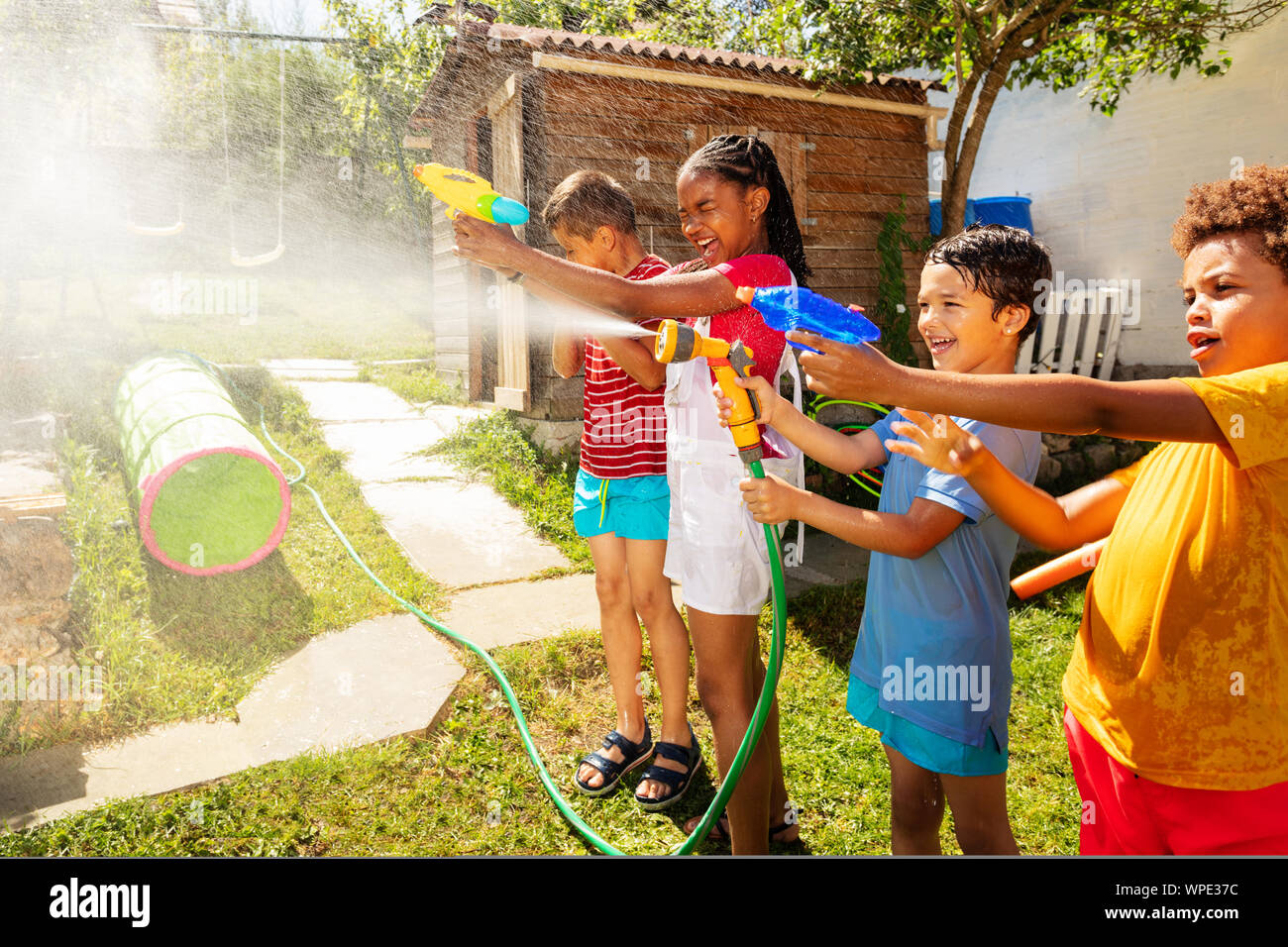 Spaß Kinder mit Wasserkanonen im Garten kämpfen Stockfoto