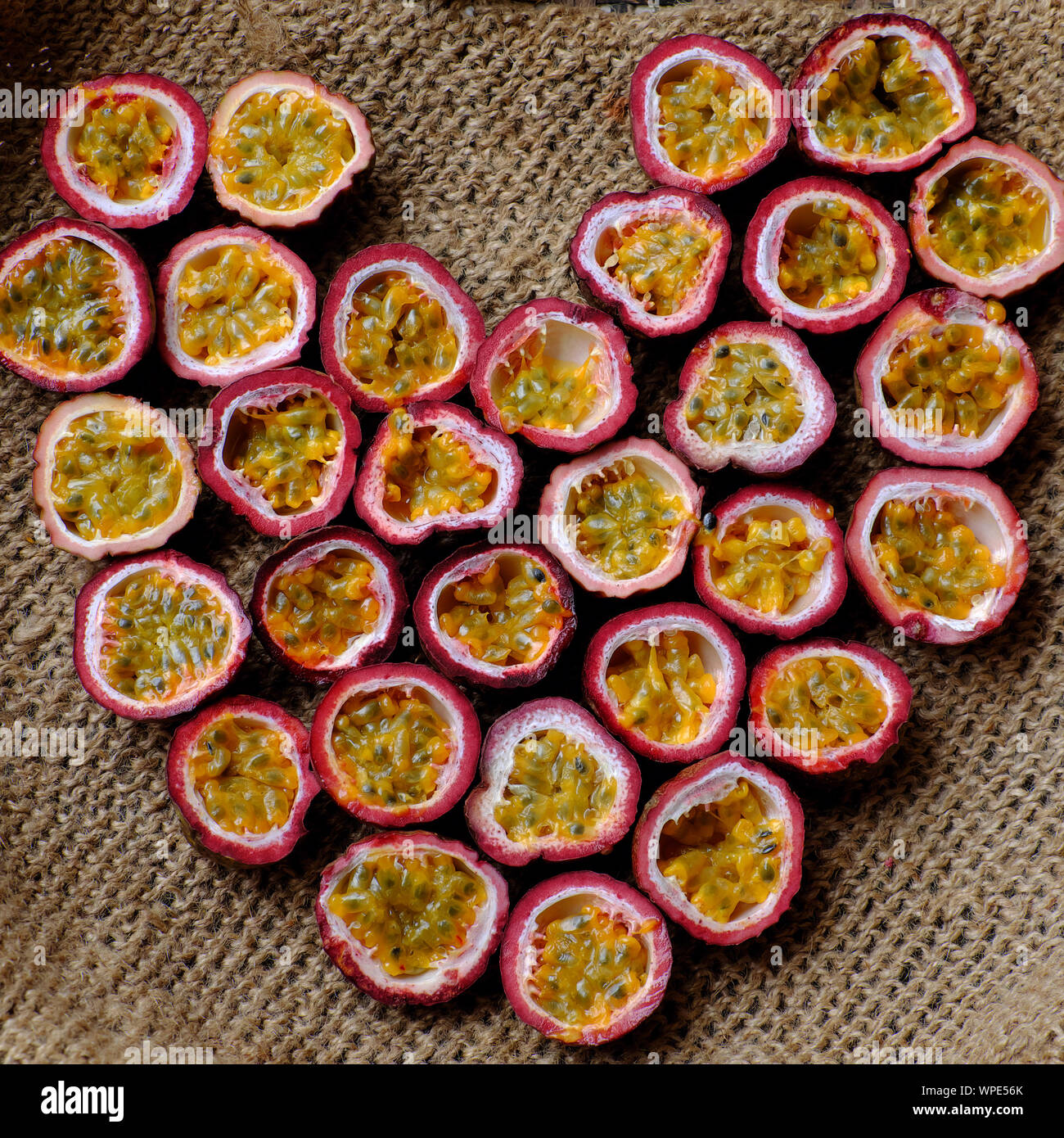 Ansicht von oben Leidenschaft Früchte in der Hälfte in Herzform Hintergrund ausschneiden, Art der zwielichtigen Obst oder passiflora edulis mit weichem Fruchtfleisch und Samen im Inneren harte Rinde Stockfoto