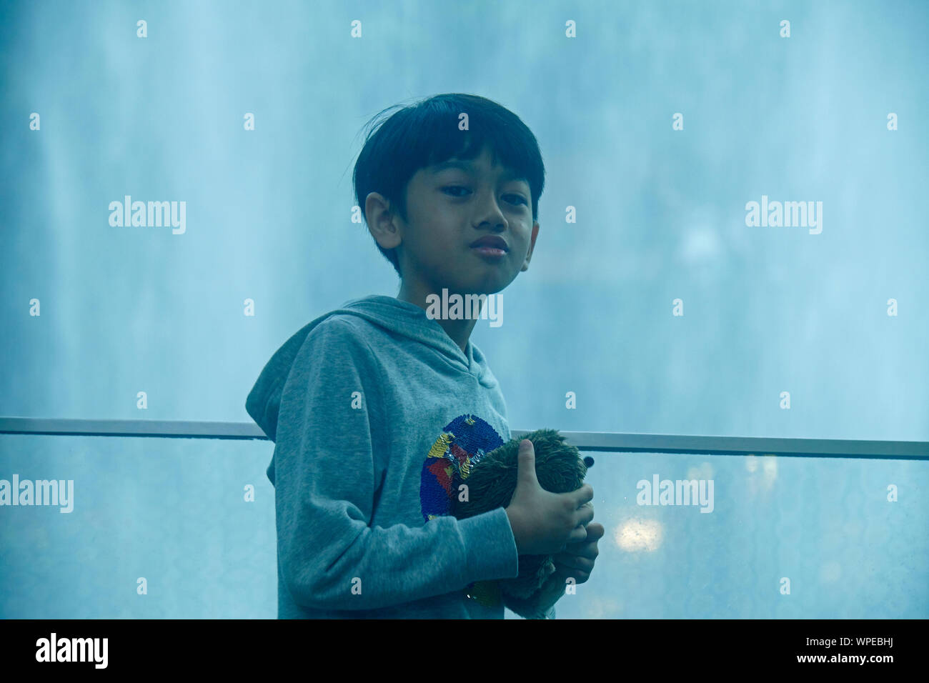 Nette junge asiatische junge Stehend vor dem Regen Vortex an Juwel in Changi Airport Stockfoto