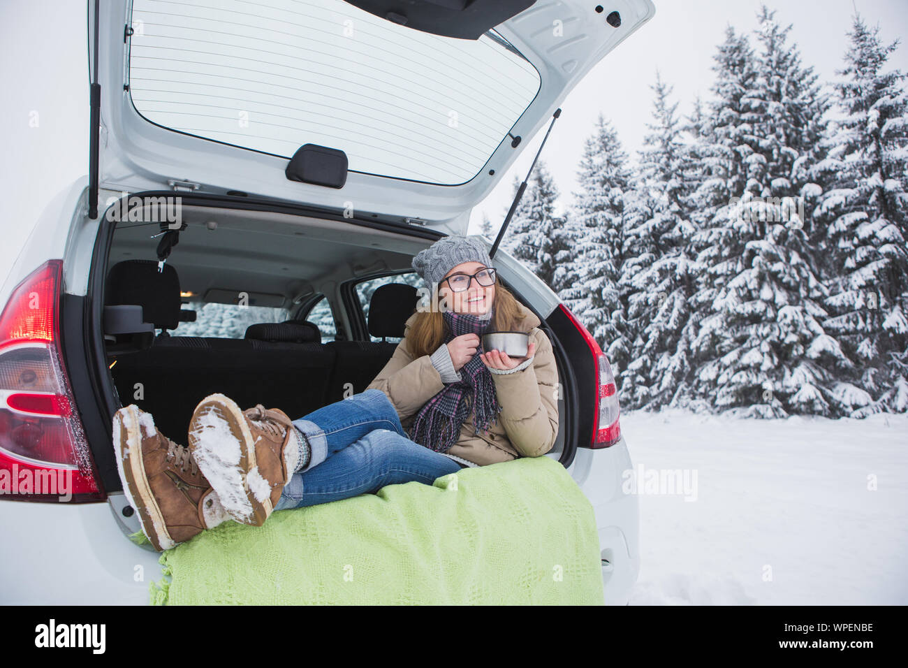 junge Frau tief Schneeräumen aus einem Auto mit einem Besen Stockfotografie  - Alamy