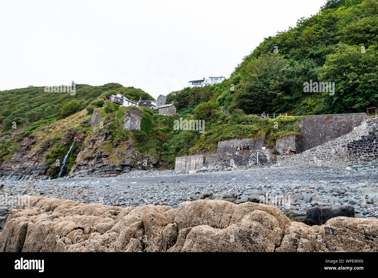Das kleine Dorf Buck's Mühlen oberhalb der felsigen Strand in Bideford Bay, North Devon, UK balanciert Stockfoto