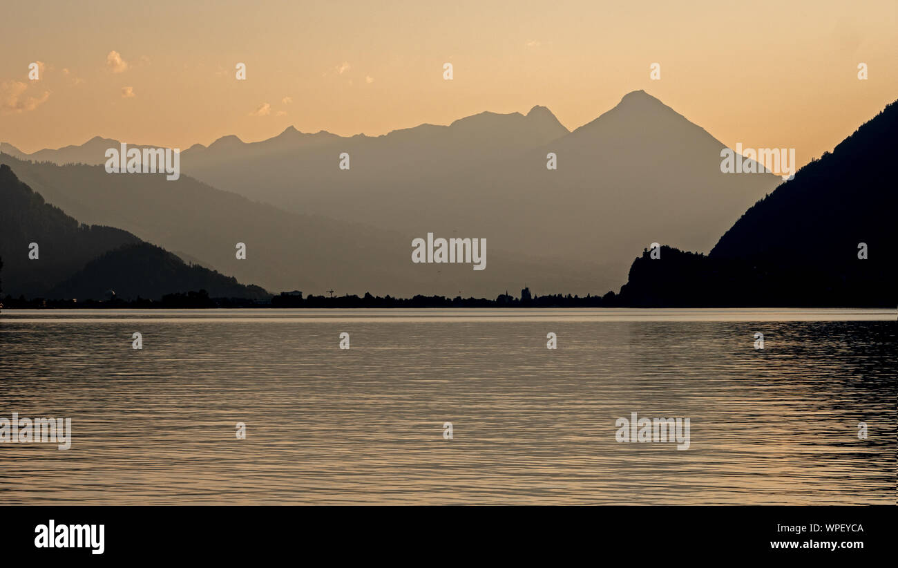 Sonnenuntergang mit Blick auf den Brienzersee in der Schweiz. Die hohen Berge werfen einen Silhouette gegen den orange sky und Reflexionen im Wasser des Stockfoto