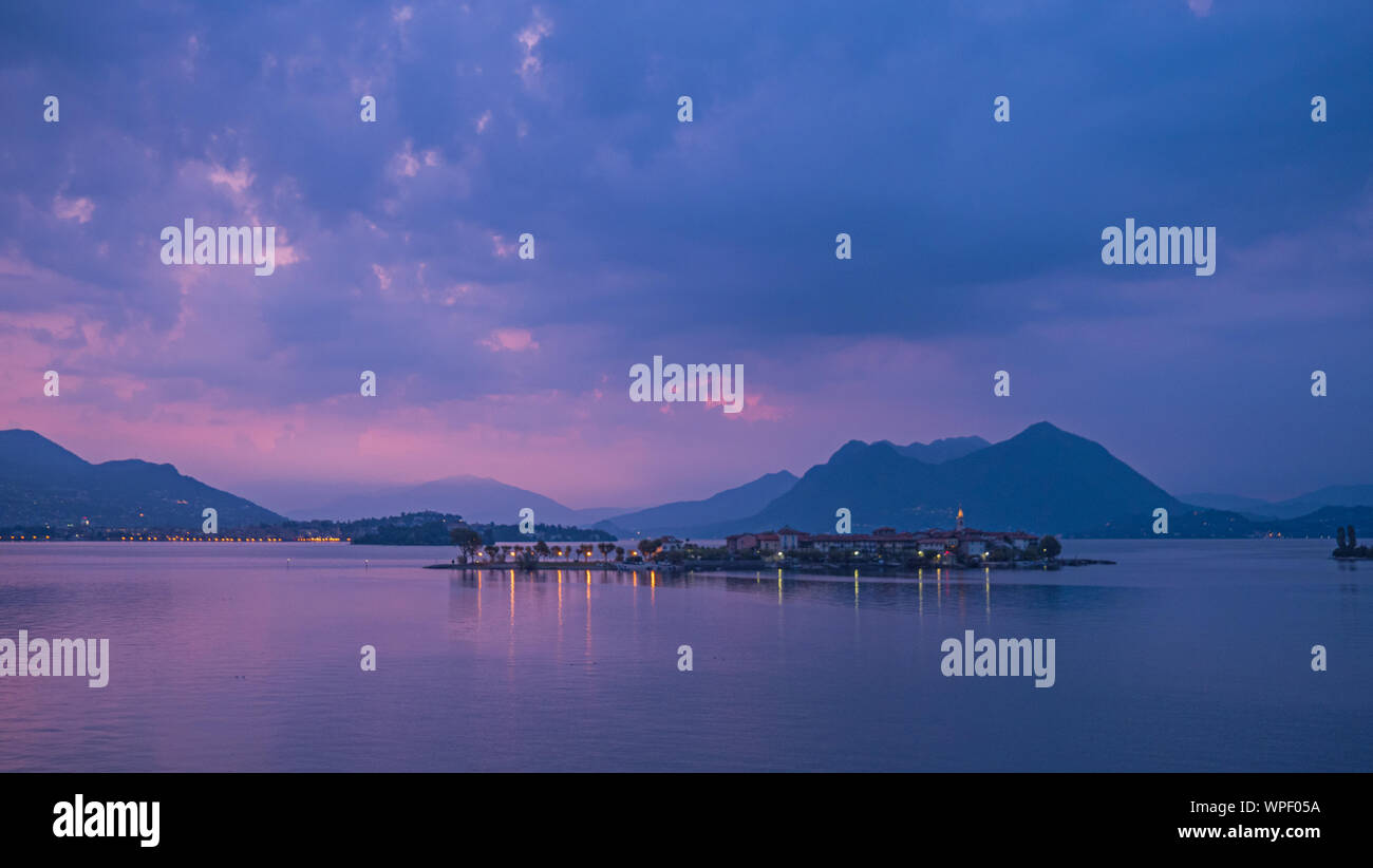 Eine lange Exposition am frühen Morgen Schuß der Lichtreflexionen auf die Gebäude auf dem kleinen See Insel Isola Bella auf dem Italienischen Lago Maggiore. Stockfoto