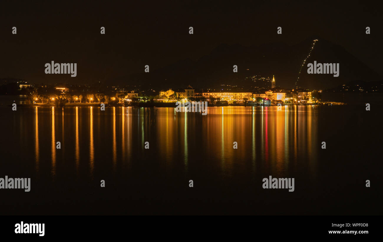 Eine Langzeitbelichtung Nacht geschossen der Lichtreflexionen auf die Gebäude auf dem kleinen See Insel Isola Bella auf dem Italienischen Lago Maggiore. Stockfoto