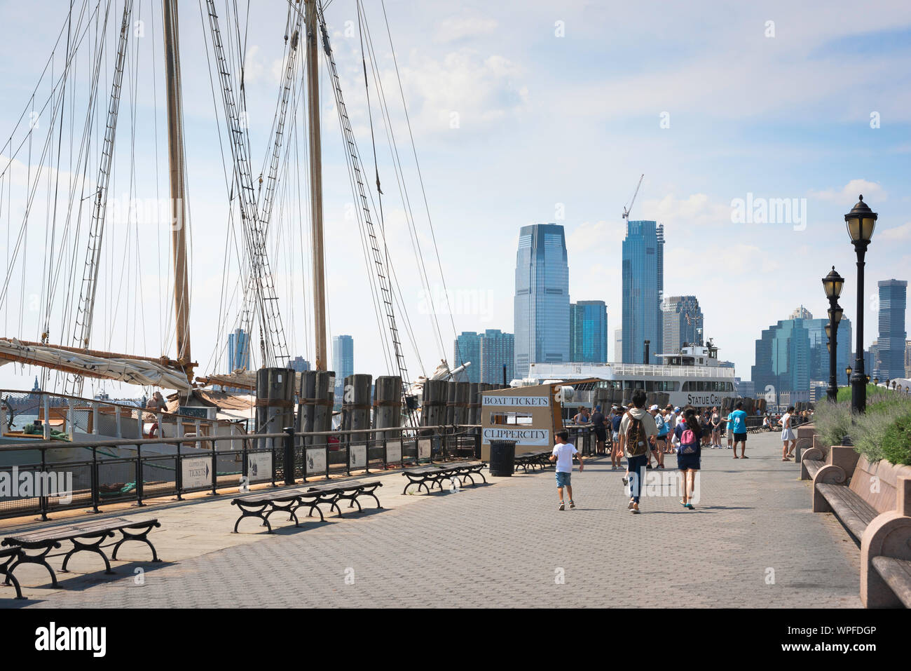 New York City Waterfront, Aussicht im Sommer von Menschen zu Fuß entlang der Battery Park Esplanade in Lower Manhattan, New York City, USA Stockfoto