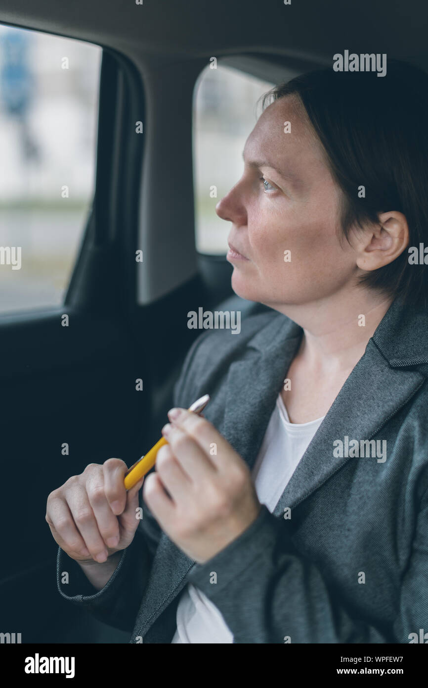 Geschäftsfrau warten an dem Auto Rücksitz und Spielen mit Bleistift Angst zu überwinden Stockfoto