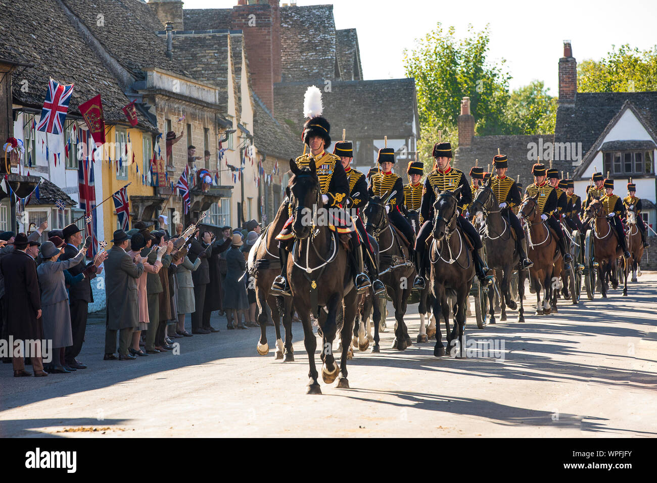 Die Könige Troop Royal Horse artillery während der Dreharbeiten zu einem Film Version von Smash TV-hit Downton Abbey für das Kino. Die Szene wurde in der Hohen St der National Trust Dorf Lacock in Wiltshire mit 80 Pferden und Gewehren durch die Street Parade. Stockfoto