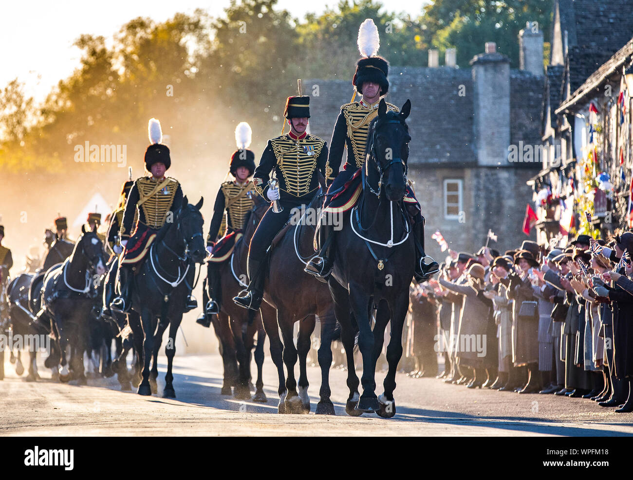 Die Könige Troop Royal Horse artillery während der Dreharbeiten zu einem Film Version von Smash TV-hit Downton Abbey für das Kino. Die Szene wurde erschossen in der Hohen St der National Trust Dorf Lacock in Wiltshire mit 80 Pferden und Gewehren und über 250 Extras zujubeln und wehenden Fahnen wie die Parade vorbei. Stockfoto