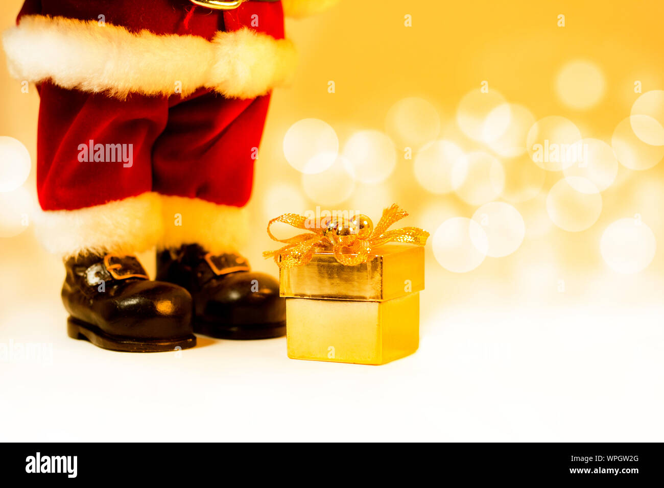 Santa Claus und Geschenk mit goldenen bokeh Hintergrund. Stockfoto